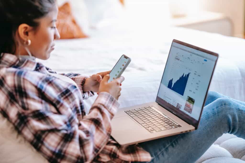 image of a woman on her phone and laptop