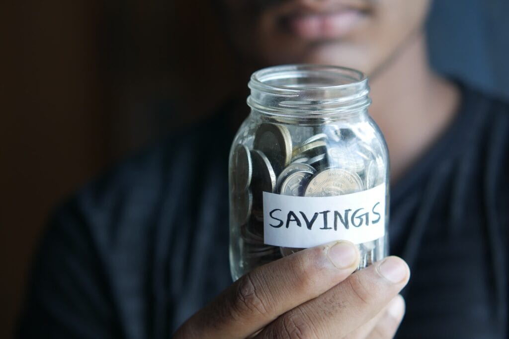 image of a man holding a savings jar