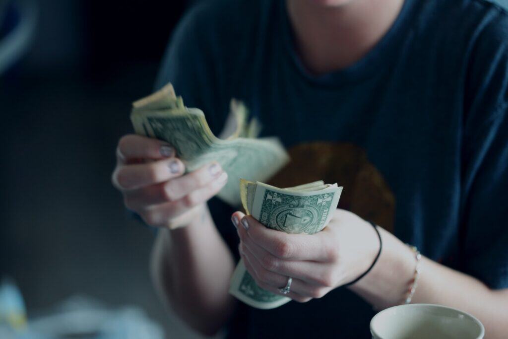image of a woman counting dollar bills