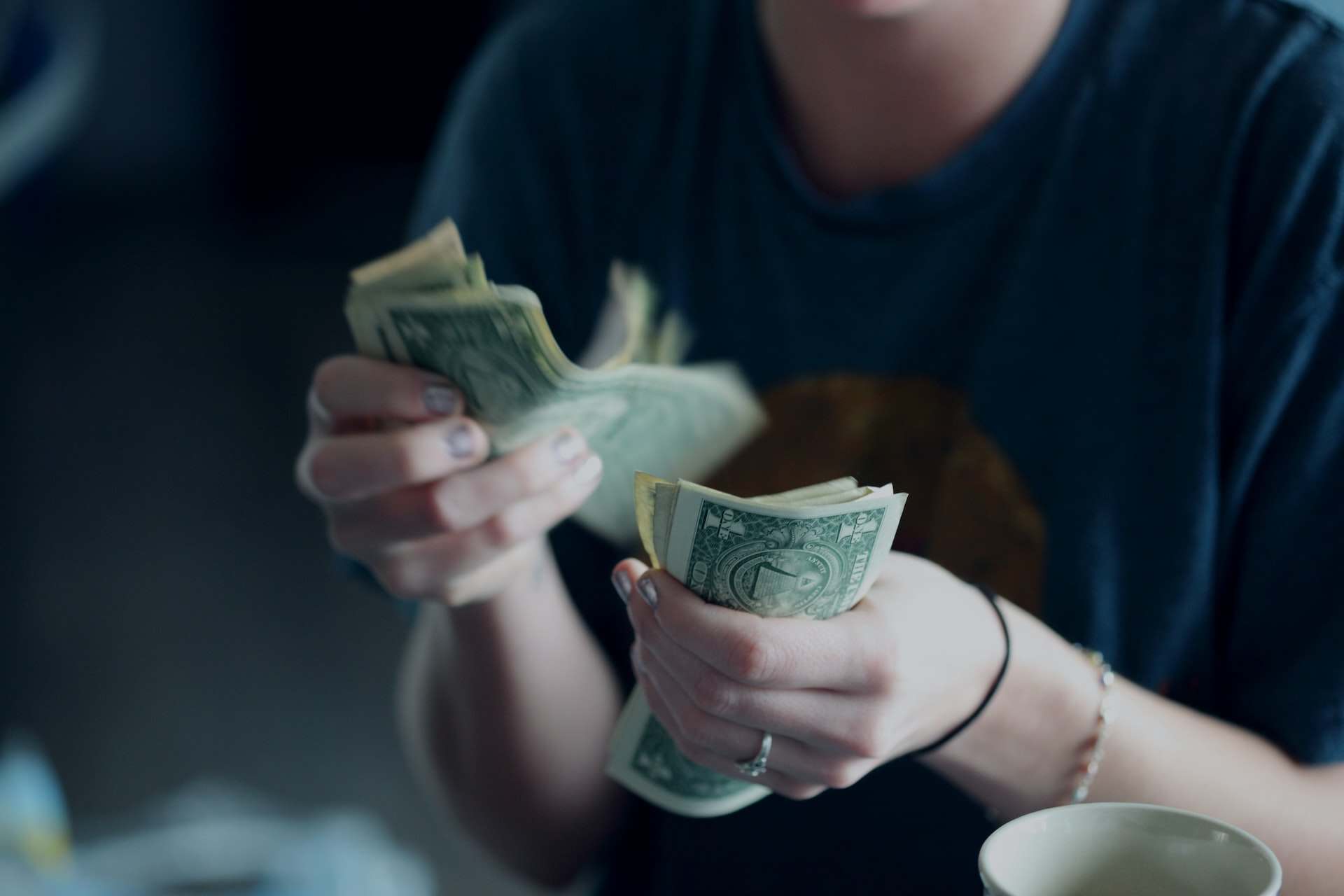 image of a woman counting dollar bills